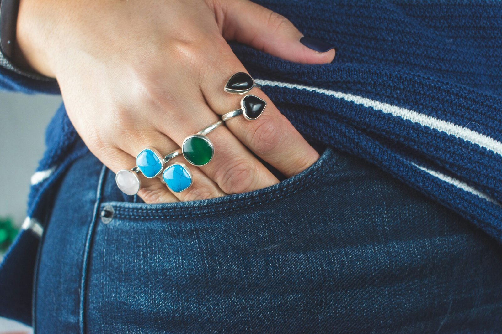 person wearing silver teal and green gemstone ring